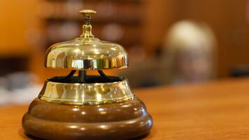 A wooden desk with a brass bell on top.