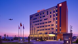 Un hôtel moderne dont le nom, «ibis HOTEL», est affiché en grand sur la façade.