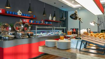 A buffet setup with various food items and utensils.