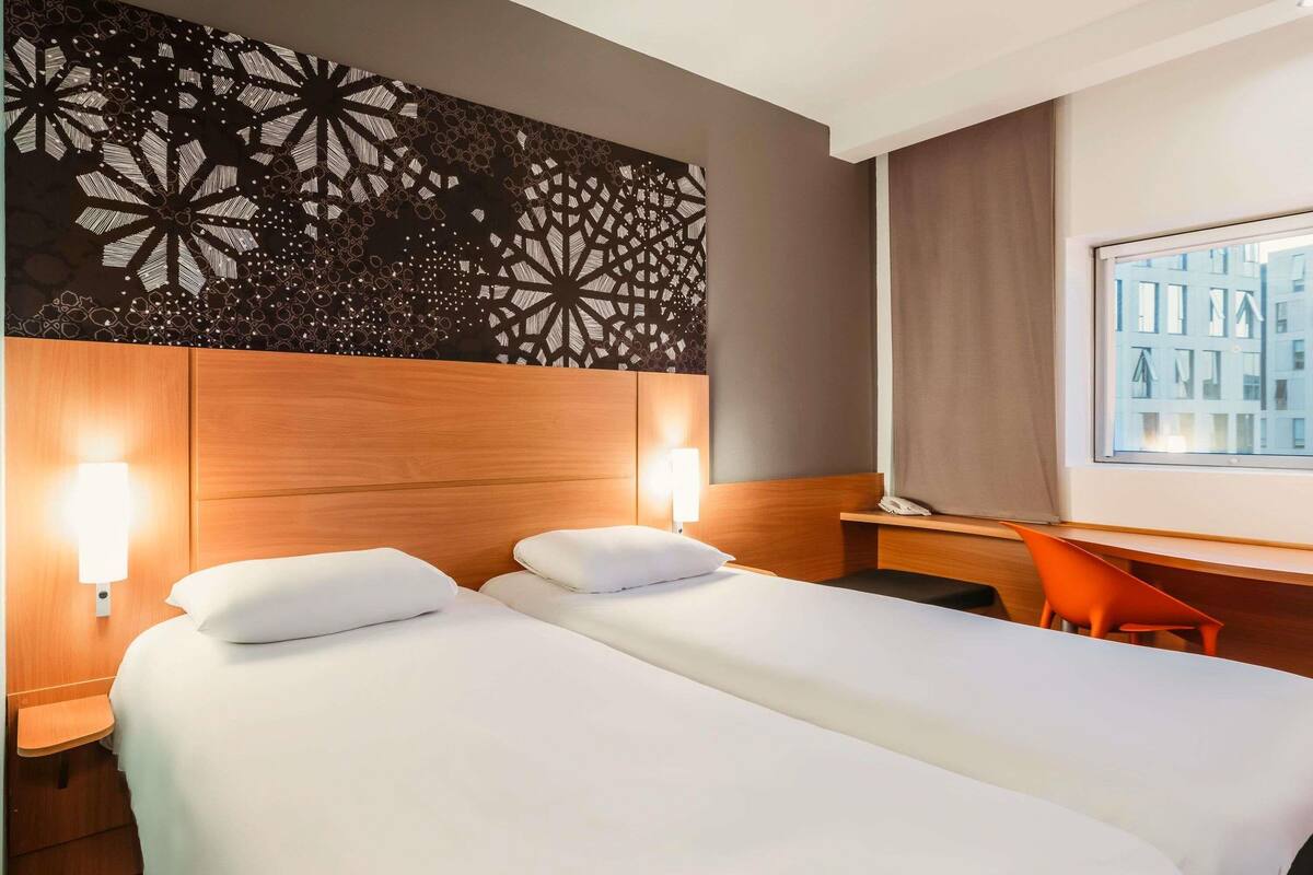 Una habitación de hotel con dos camas, un escritorio y una silla.