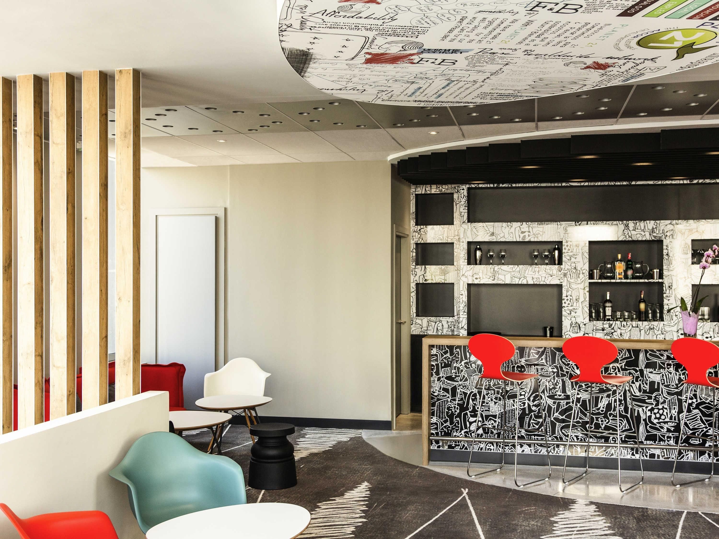 Een moderne lobby met een bar, een uniek plafondontwerp, modern meubilair en een behang met patroon.