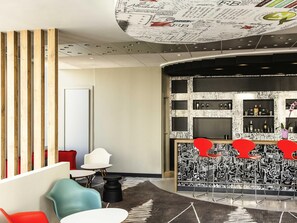 Un vestíbulo moderno con zona de bar, que presenta un diseño de techo único, muebles contemporáneos y una pared estampada.