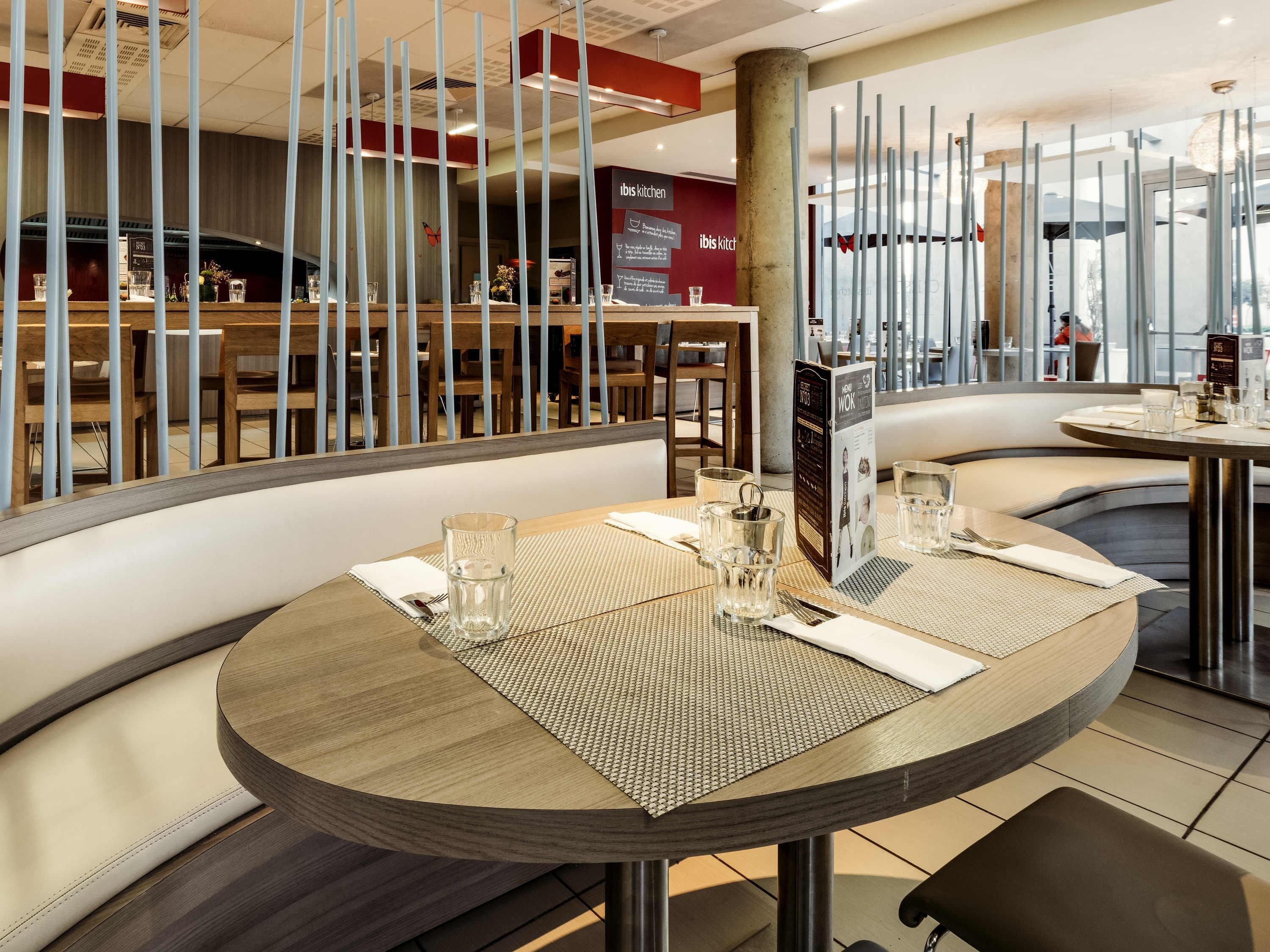 A restaurant interior with round tables, high stools, and a modern design.