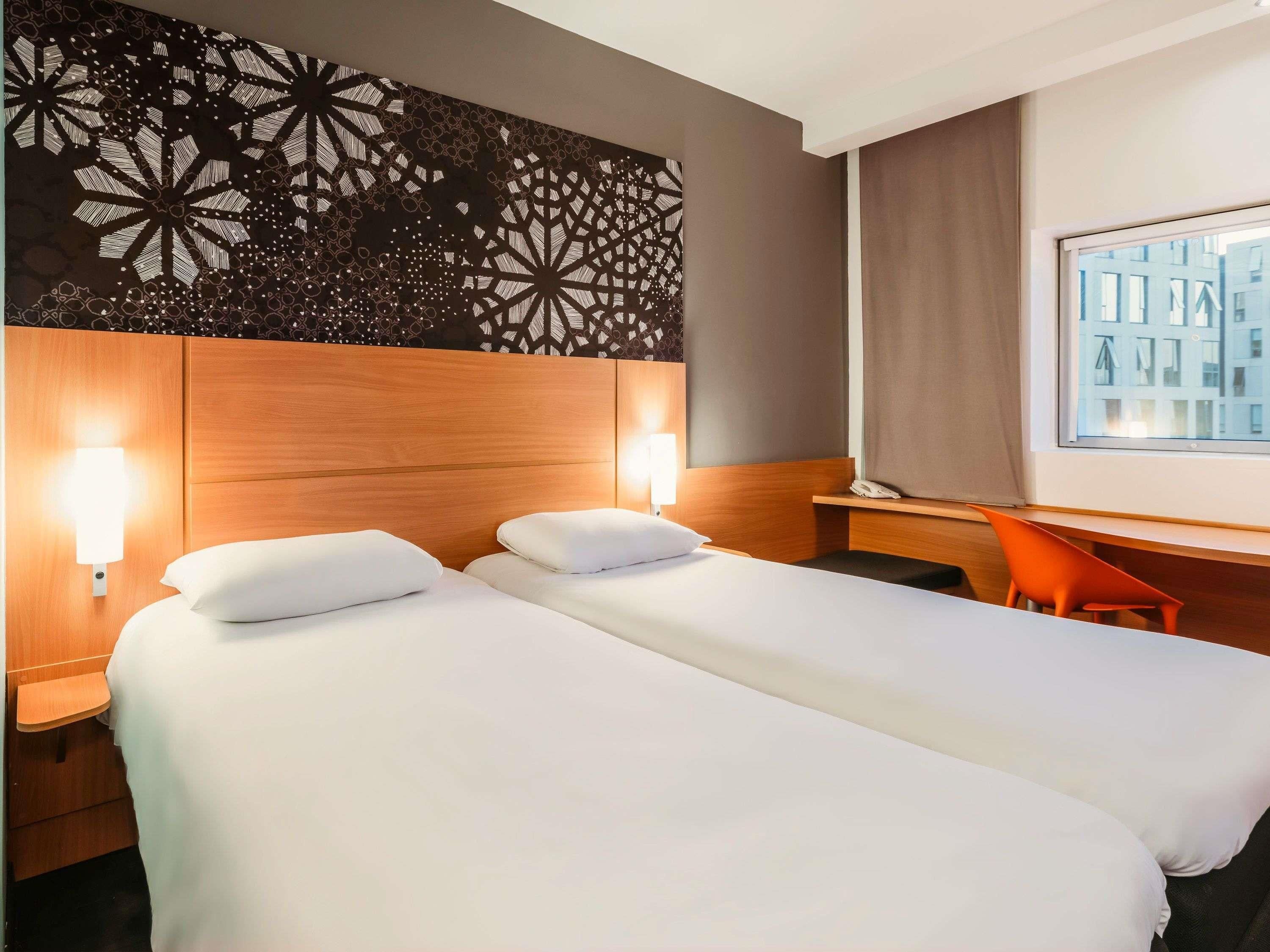 Una habitación de hotel con dos camas, un escritorio y una silla.