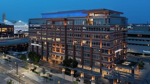 Un hôtel à plusieurs étages, doté d’un design moderne, avec une entrée imposante, une allée couverte et une cour intérieure.