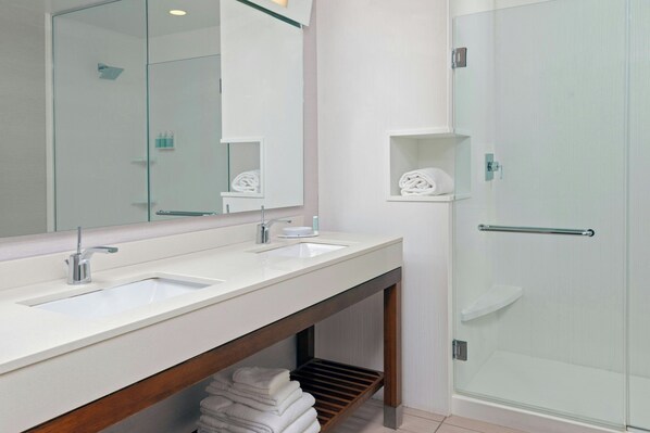 A modern bathroom with two sinks, a large mirror, and a glass-enclosed shower. - Courtyard Buffalo Downtown / Canalside (Buffalo)