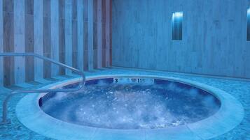 A hot tub with a tiled floor and a metal ladder.
