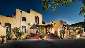 A building with a stucco exterior, multiple windows, and a staircase leading to the entrance. - Hotel Rural Finca Salamanca (Güímar)