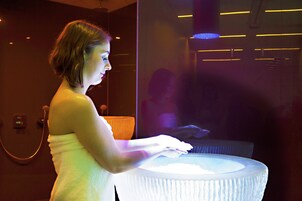 A person using a digital interface in a modern bathroom with a visible shower and a towel rack.