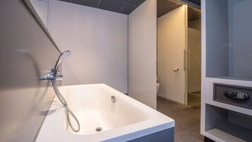 A modern bathroom with a freestanding bathtub, a shower, and a toilet.