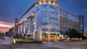 Un hotel moderno con fachada curva, varios pisos y un llamativo letrero DoubleTree by Hilton.