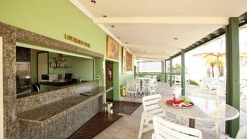 A restaurant area with a counter, seating, and a view of the outdoors.