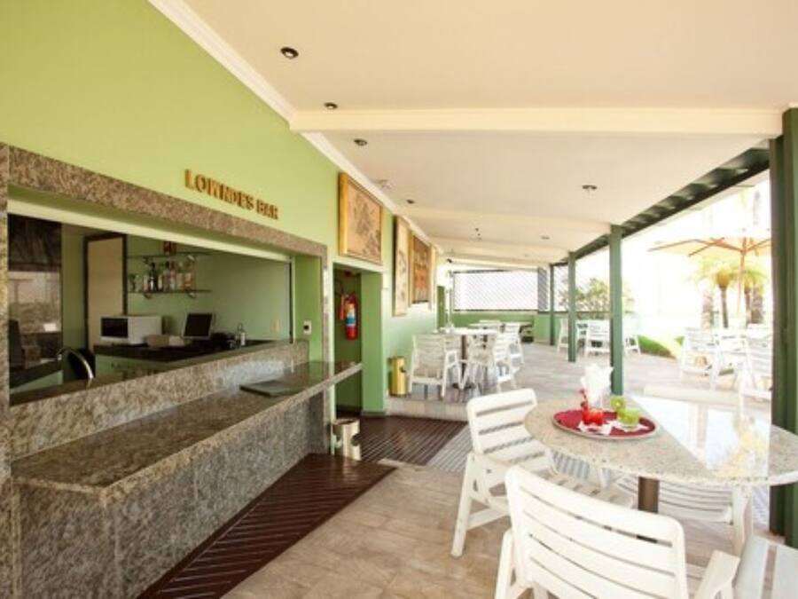 A restaurant area with a counter, seating, and a view of the outdoors.