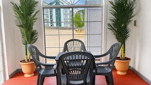 A room with a red floor, a large arched window, and two potted plants. - Carriage House Inn (Branson)