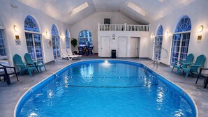 An indoor swimming pool with clear blue water, a 3-foot depth marking, and a set of stairs leading into the pool. - Carriage House Inn (Branson)