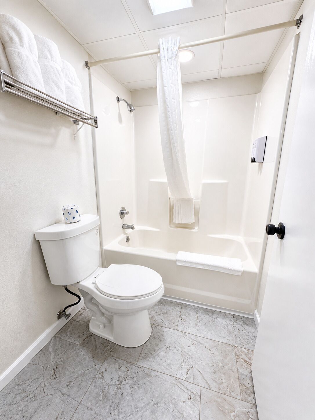 Une salle de bain équipée de toilettes, d’une baignoire et d’un rideau de douche.