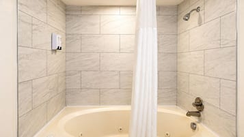 Habitación, 1 cama de matrimonio grande, bañera de hidromasaje | Baño | Ducha y bañera combinadas y artículos de higiene personal gratuitos
