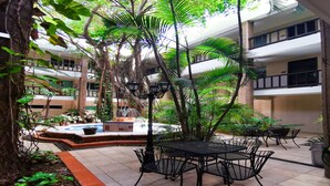 A courtyard with a pool, outdoor seating, and lush greenery. - Hotel Colonial Cancun (Cancun)