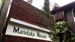 A sign for 'Mandala House' with a brick facade and a balcony. - Mandala House (Chiang Mai)