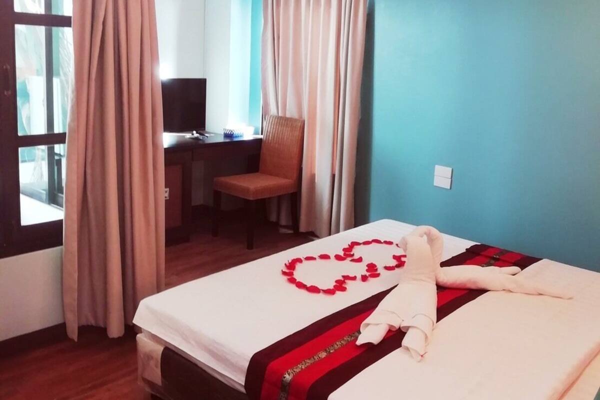 A hotel room with a bed, a desk, and a chair.