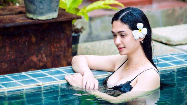 A person in a swimming pool with a potted plant nearby. - Mandala House (Chiang Mai)