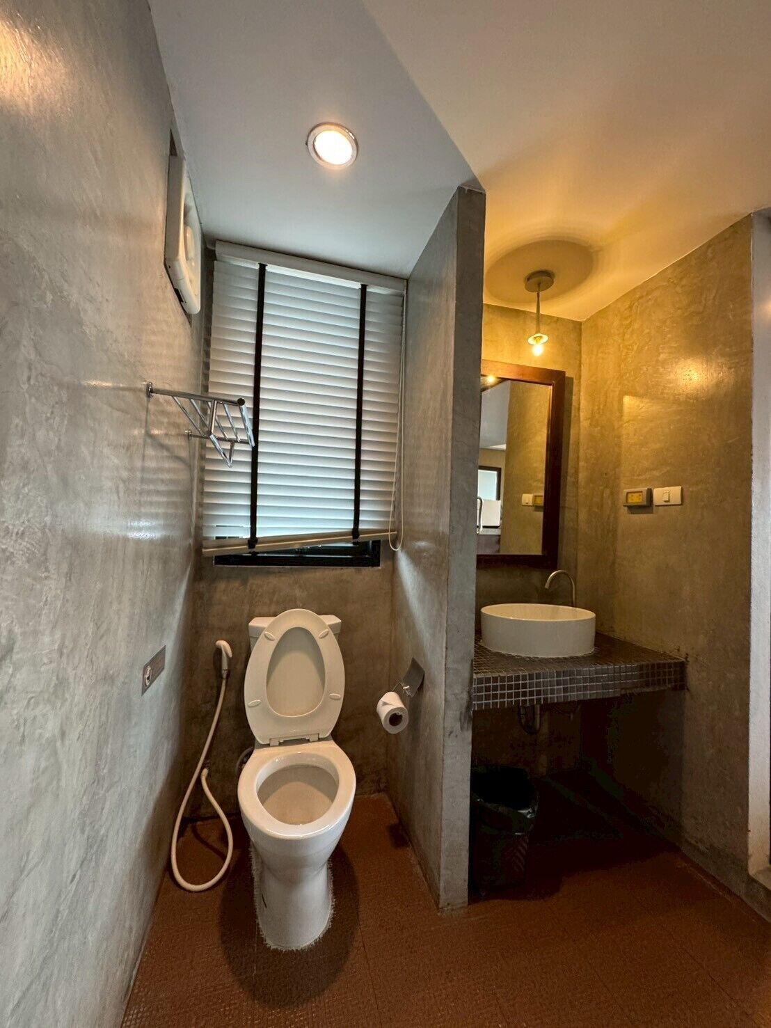 A compact bathroom with a toilet, sink, and window.
