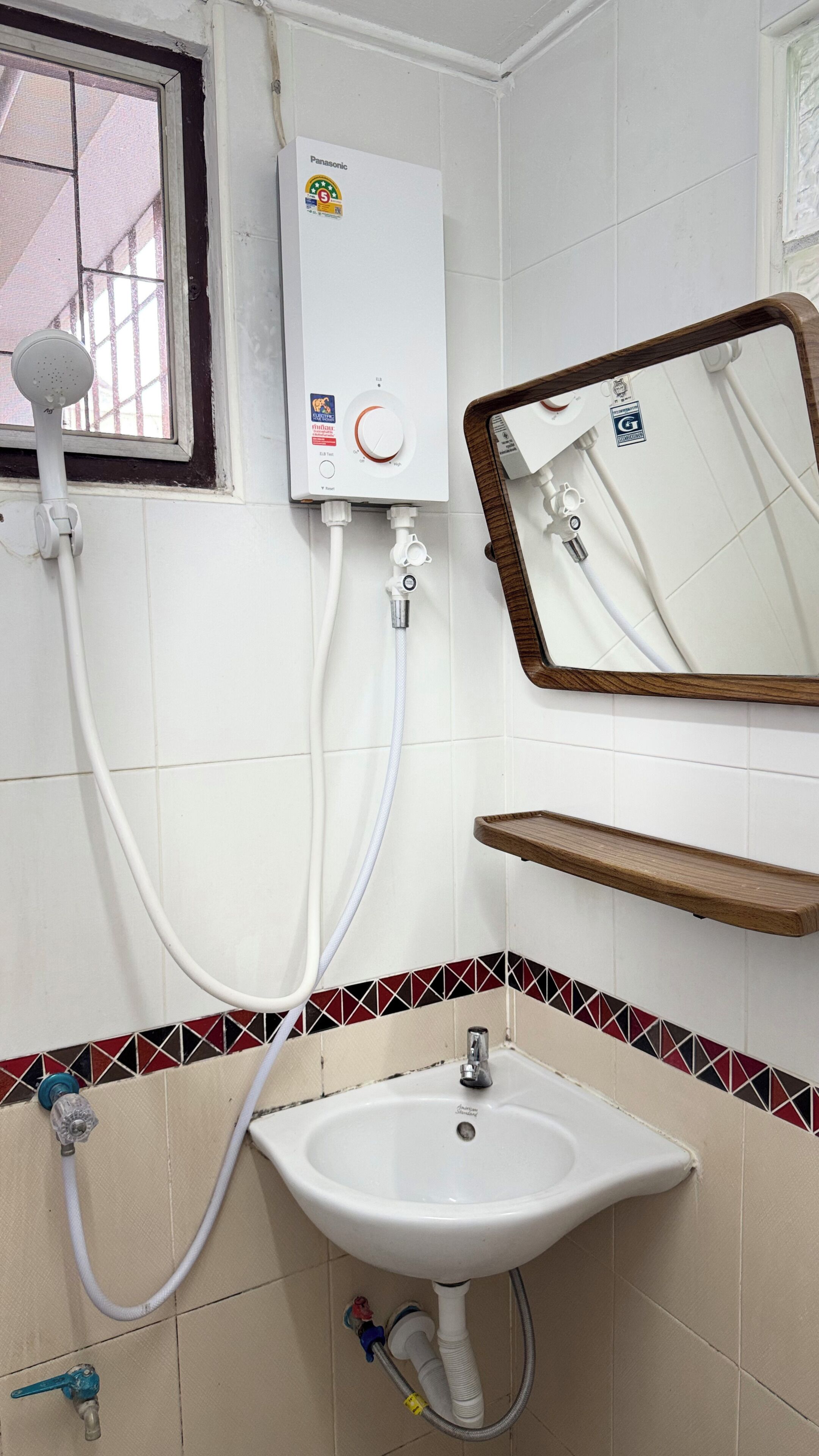 Ein Badezimmer mit Waschbecken, Spiegel, Dusche und Toilette.