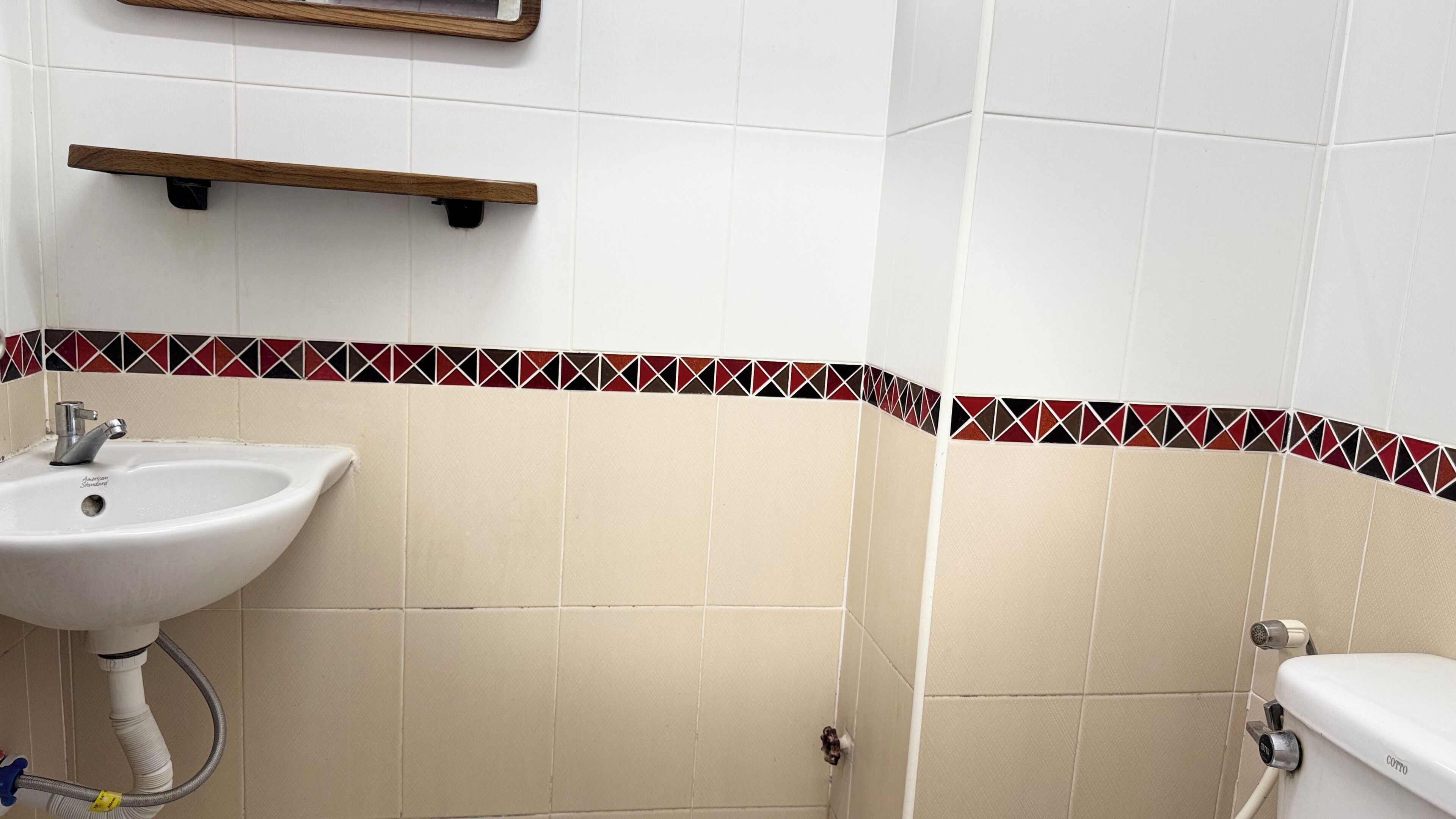Une salle de bain avec un lavabo blanc, des toilettes et une douche.