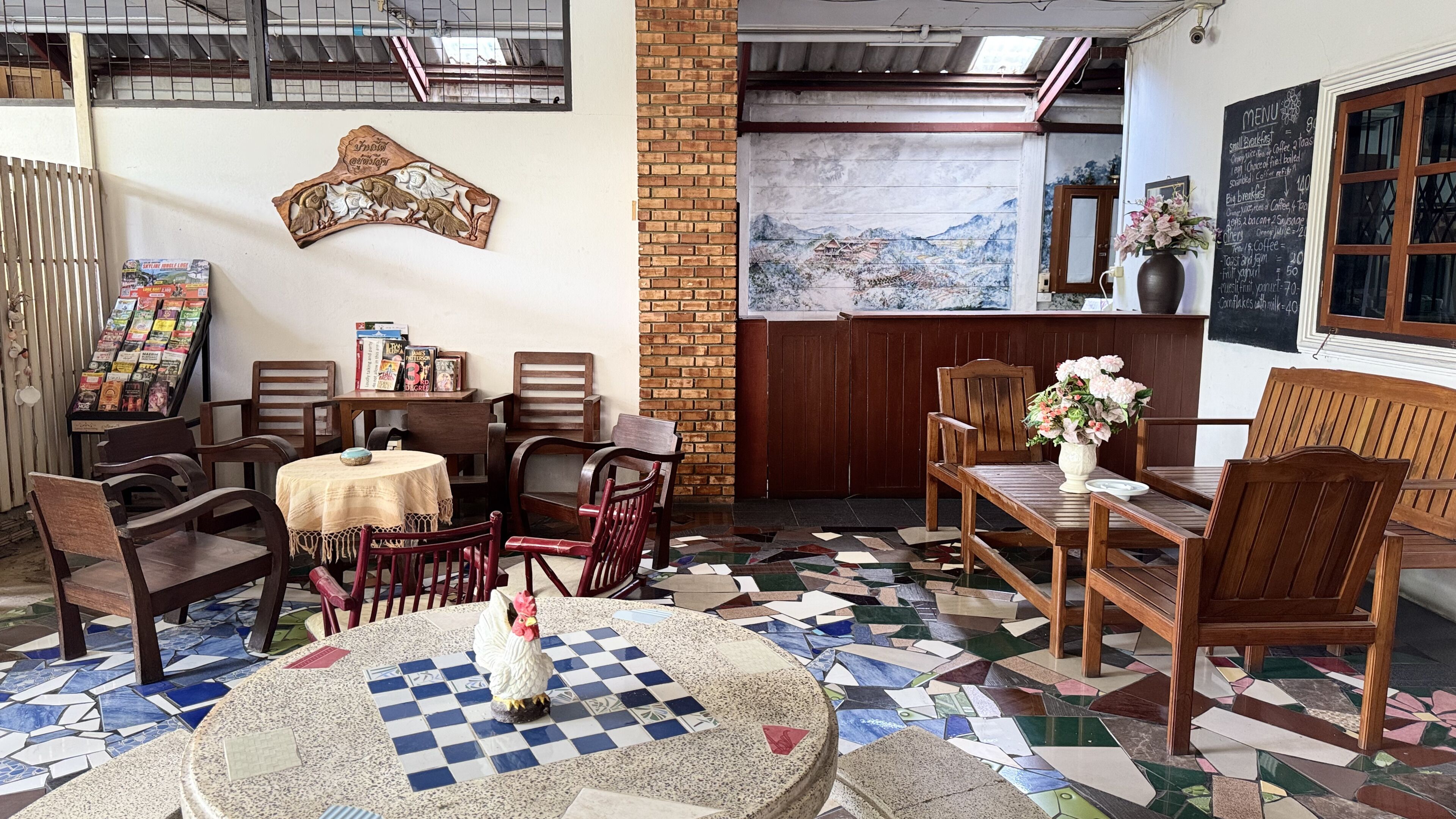 Um restaurante acolhedor com mobiliário de madeira, piso em mosaico e um menu na parede.
