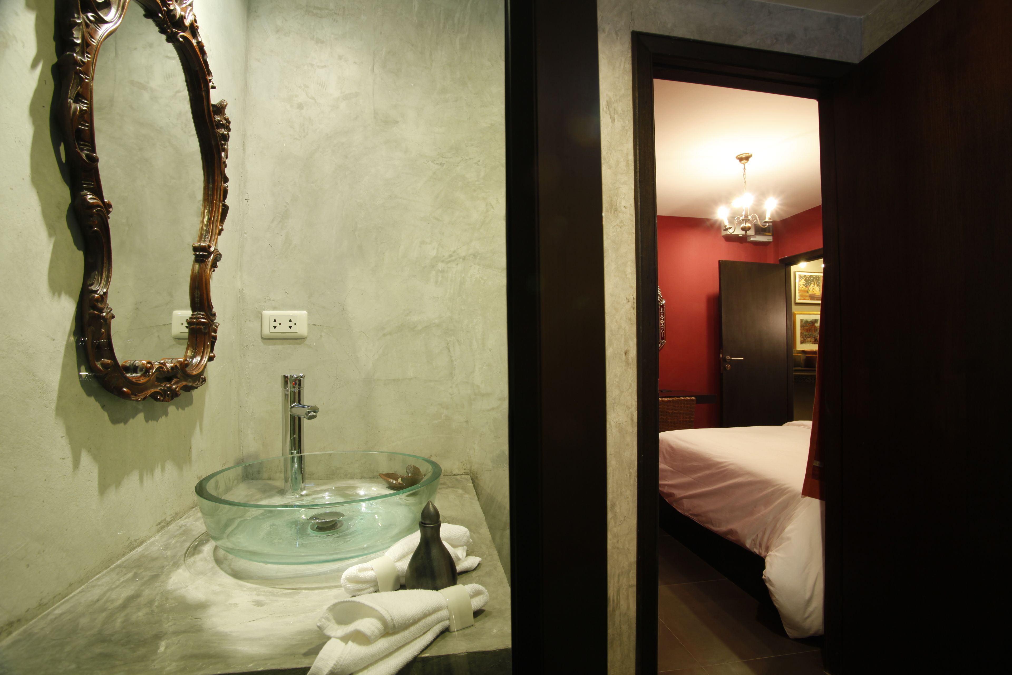 A bathroom with a glass bowl sink, a mirror, and a towel rack.