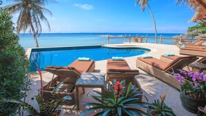 A poolside area with lounge chairs and a view of the ocean. - Beyond The Blue Horizon Villa Resort (Ko Pha-ngan)