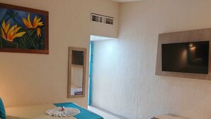 Une chambre d’hôtel avec deux lits, un téléviseur fixé au mur et un tableau accroché au mur.
