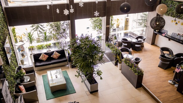 A spacious lobby with a central seating area, large windows, and indoor plants. - Prescott Hotel Bukit Bintang (Kuala Lumpur)