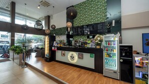A coffee shop interior with a wooden counter, menu board, and a refrigerated drink dispenser. - Prescott Hotel Bukit Bintang (Kuala Lumpur)