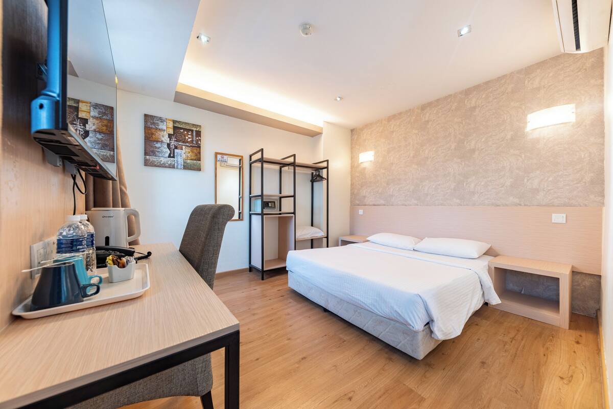 Une chambre d’hôtel moderne équipée d’un lit, d’un bureau, d’une chaise et d’une armoire.