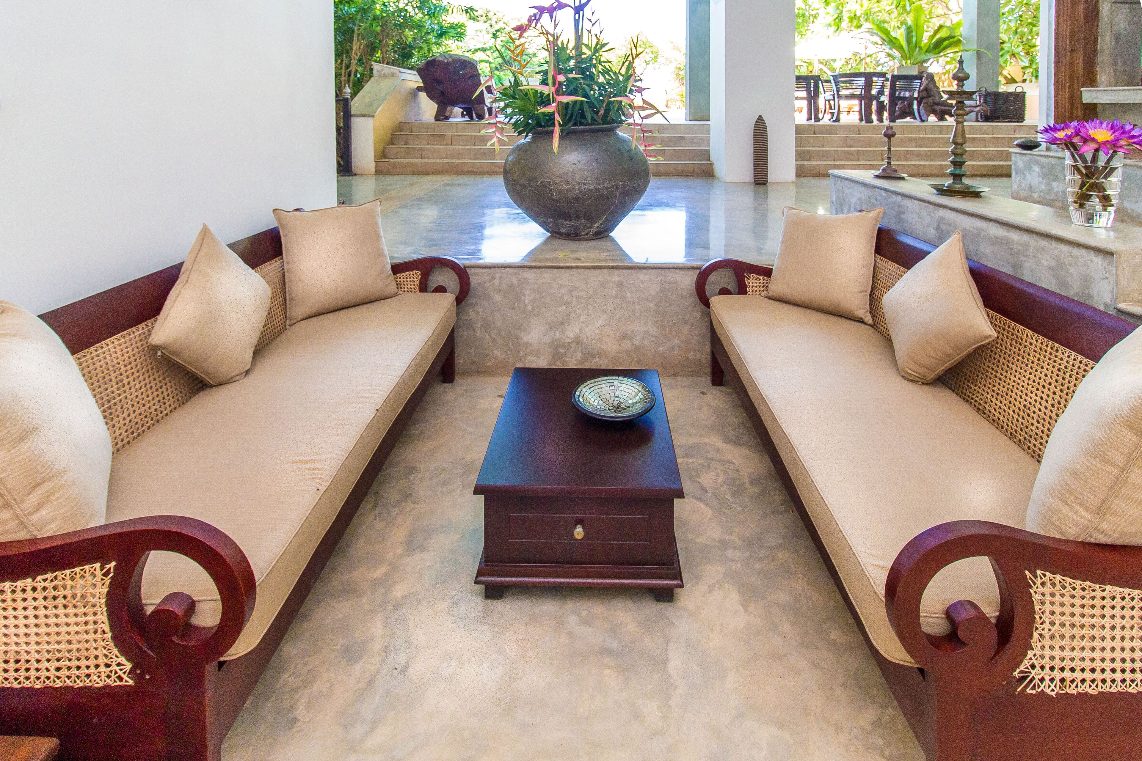 A lobby with two sofas, a coffee table, and a large vase with flowers.