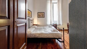 A bedroom with a wooden bed, a ceiling fan, and a window with curtains. - Nova Domizia (Rome)