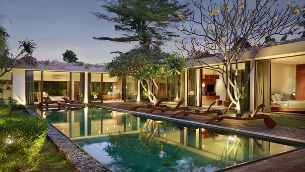 Uma casa moderna com piscina, amplas janelas de vidro e um jardim bem cuidado.