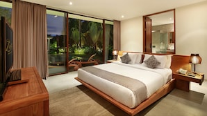 Um quarto espaçoso com uma cama grande, uma escrivaninha de madeira e vista para um jardim exuberante através de janelas do chão ao teto.