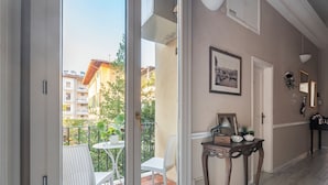 A room with a sliding glass door leading to an outdoor balcony, a small table with a chair, and a framed picture on the wall. - Opera Boutique B&B (Florence)