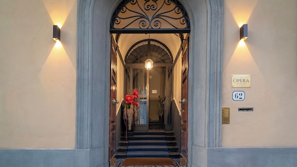 An entrance with a staircase, a sign reading 'OPERA,' and a doorbell. - Opera Boutique B&B (Florence)