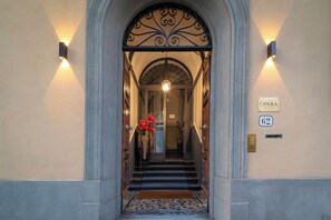 An entrance with a staircase, a sign reading 'OPERA,' and a doorbell. - Opera Boutique B&B (Florence)