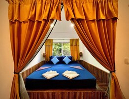 Una cama con un colchón azul, dos almohadas y dos toallas dobladas.