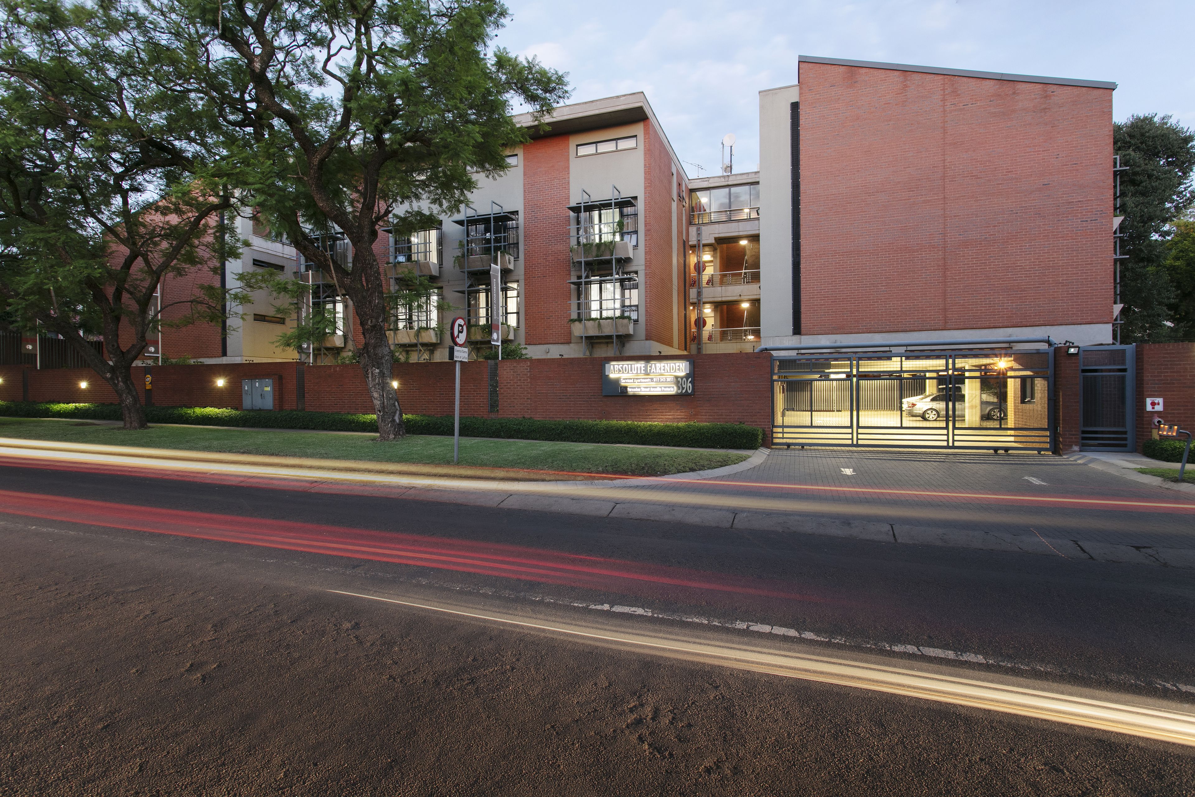 A modern building with a brick facade, large windows, and a visible entrance.