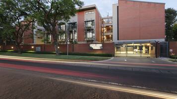 A modern building with a brick facade, large windows, and a visible entrance.