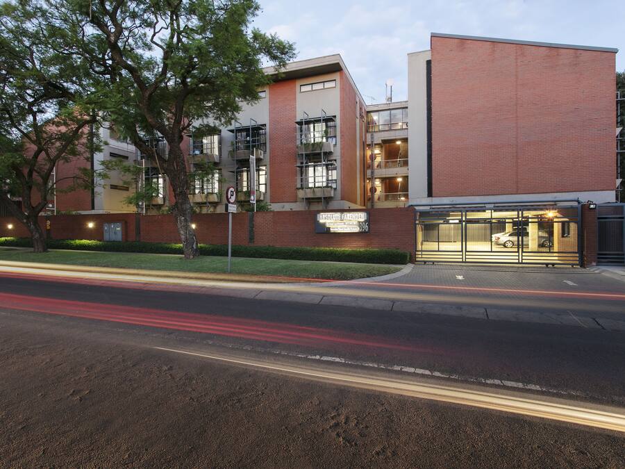 A modern building with a brick facade, large windows, and a visible entrance.