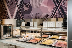 A buffet area with various food items and a refrigerated display case.