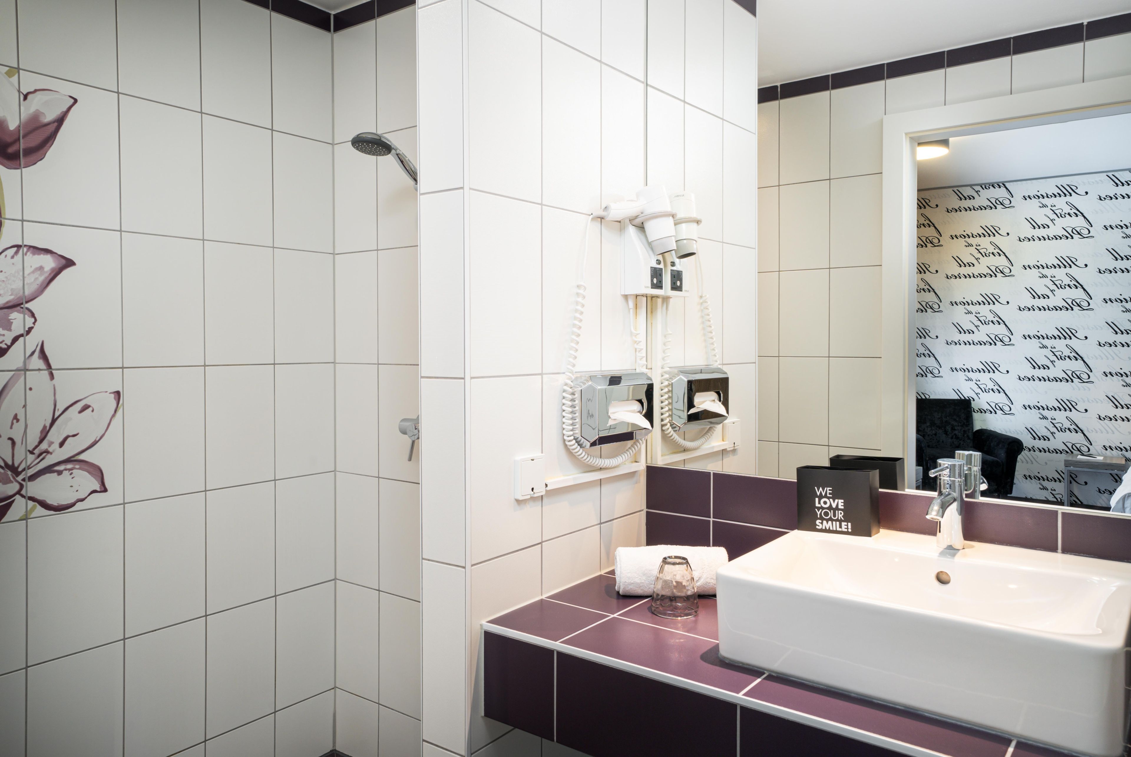 A bathroom with a white sink, a mirror, and a towel rack.