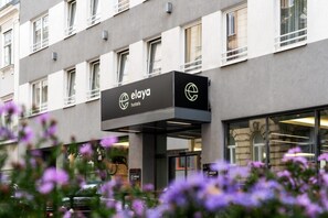 Ein Hotelgebäude mit moderner Fassade, einem Schild mit dem Hotelnamen und freiem Blick auf den Eingang.
