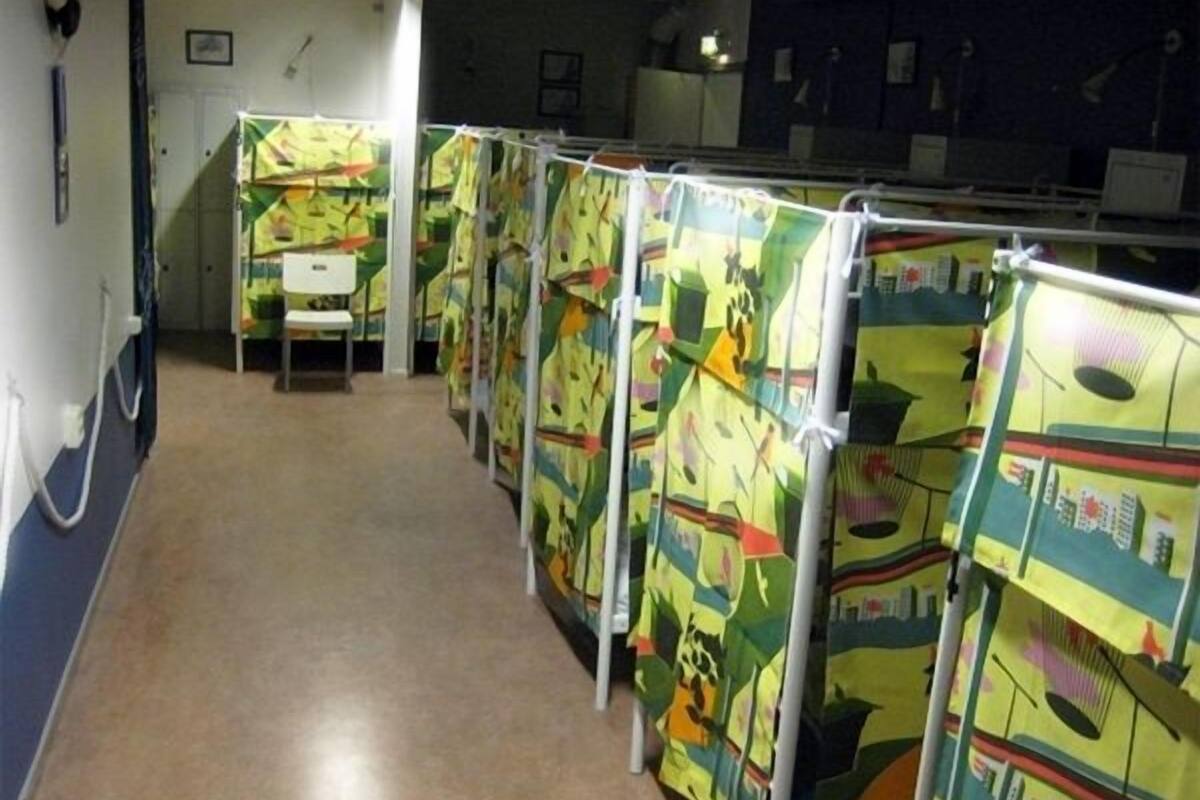 Une rangée de bureaux individuels dont les cloisons sont décorées d’œuvres d’art colorées.